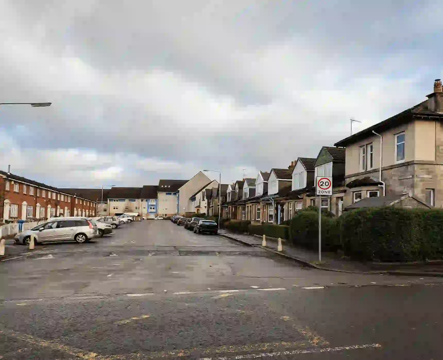 Residential street with parked cars and 20mph sign