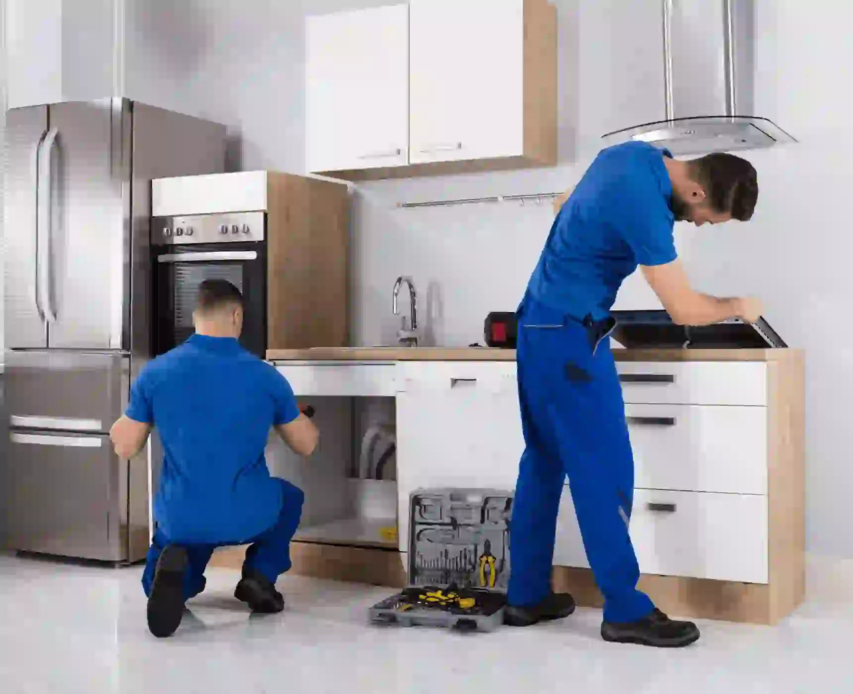 Two technicians repairing kitchen sink and cooktop